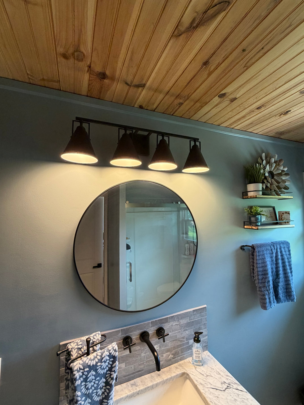 30-inch round black mirror above narrow vanity in Better Within guest bathroom