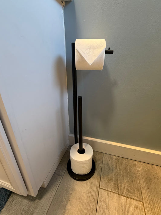 Black freestanding toilet paper holder with extra roll storage in Better Within guest bathroom