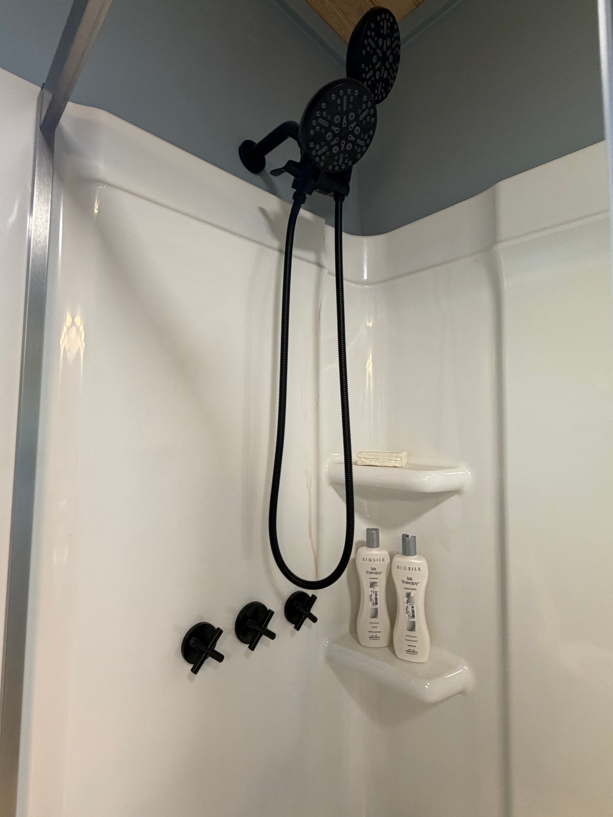 Matte black 3-handle shower system installed in Better Within guest bathroom