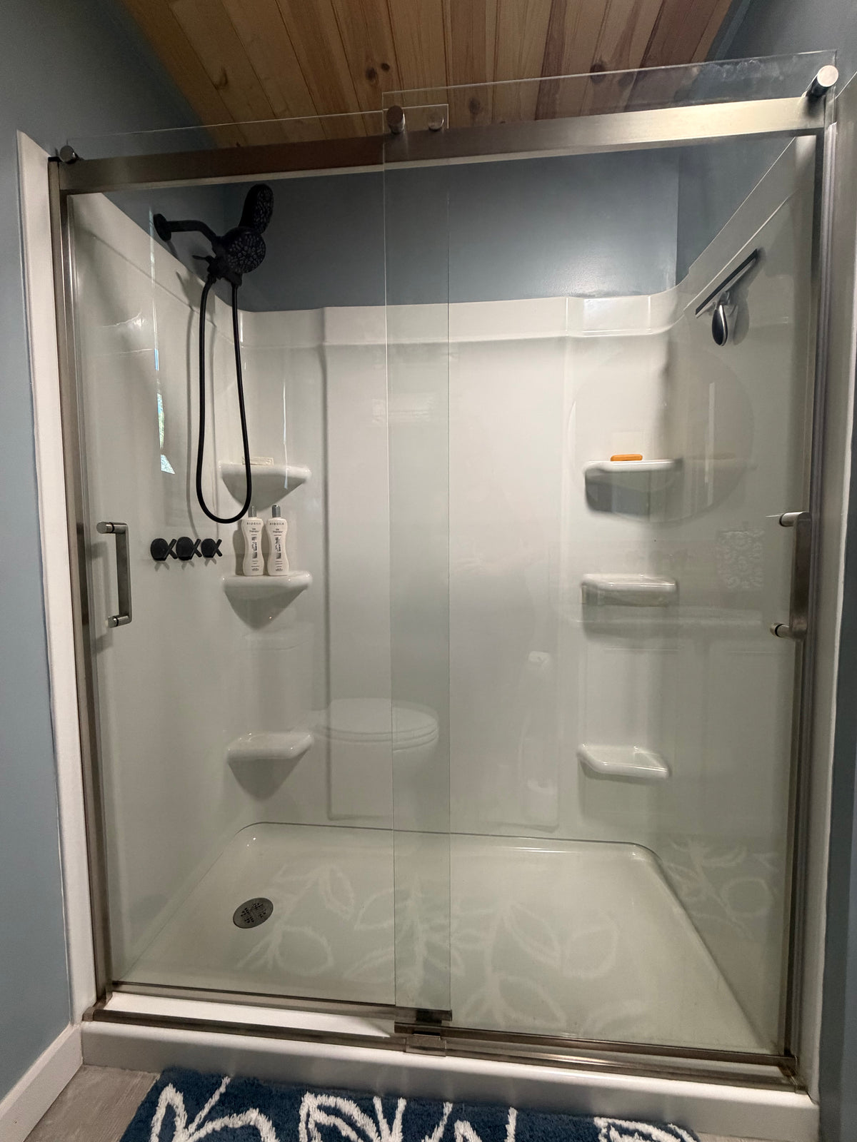 Matte black dual shower head system inside glass shower in Better Within guest bathroom