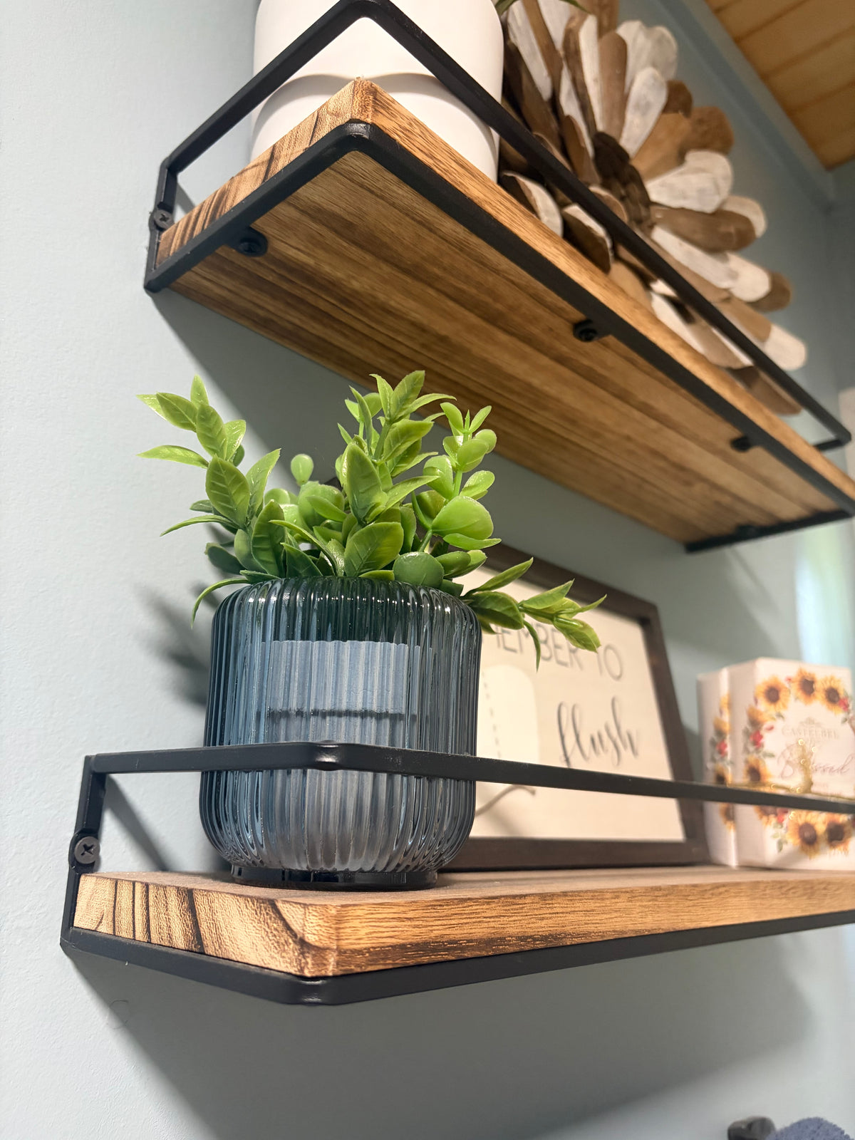 Rustic wood floating shelves with black metal rails in Better Within guest bathroom